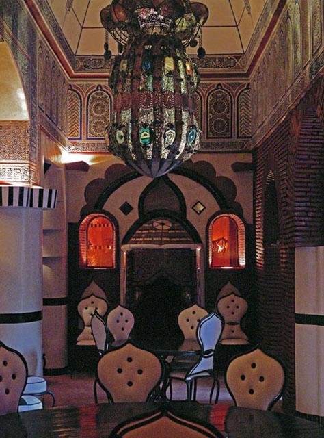 Interior view of the restaurant showing the contrast between traditional arches, wall decorations, lanterns, and the modern furniture 